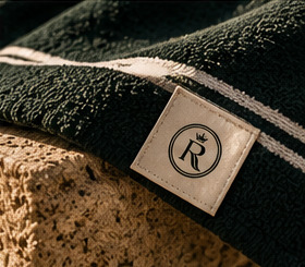 Woven emblem label on a green striped towel